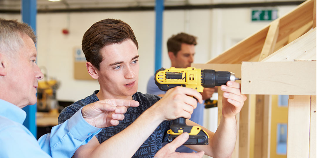 Teacher Helping College Student Studying Carpentry 